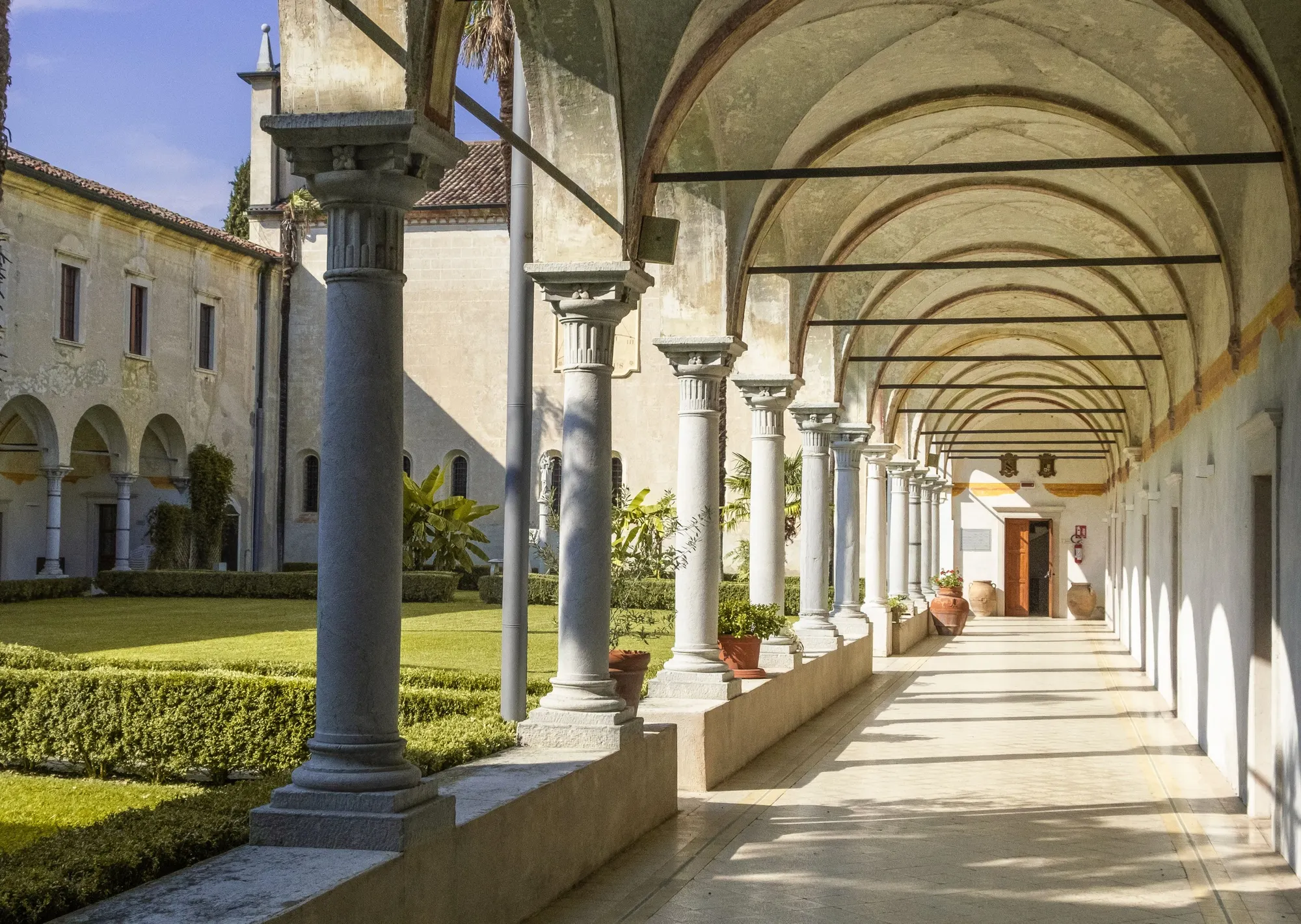 Arcaded cloister walkway opening onto a garden courtyard