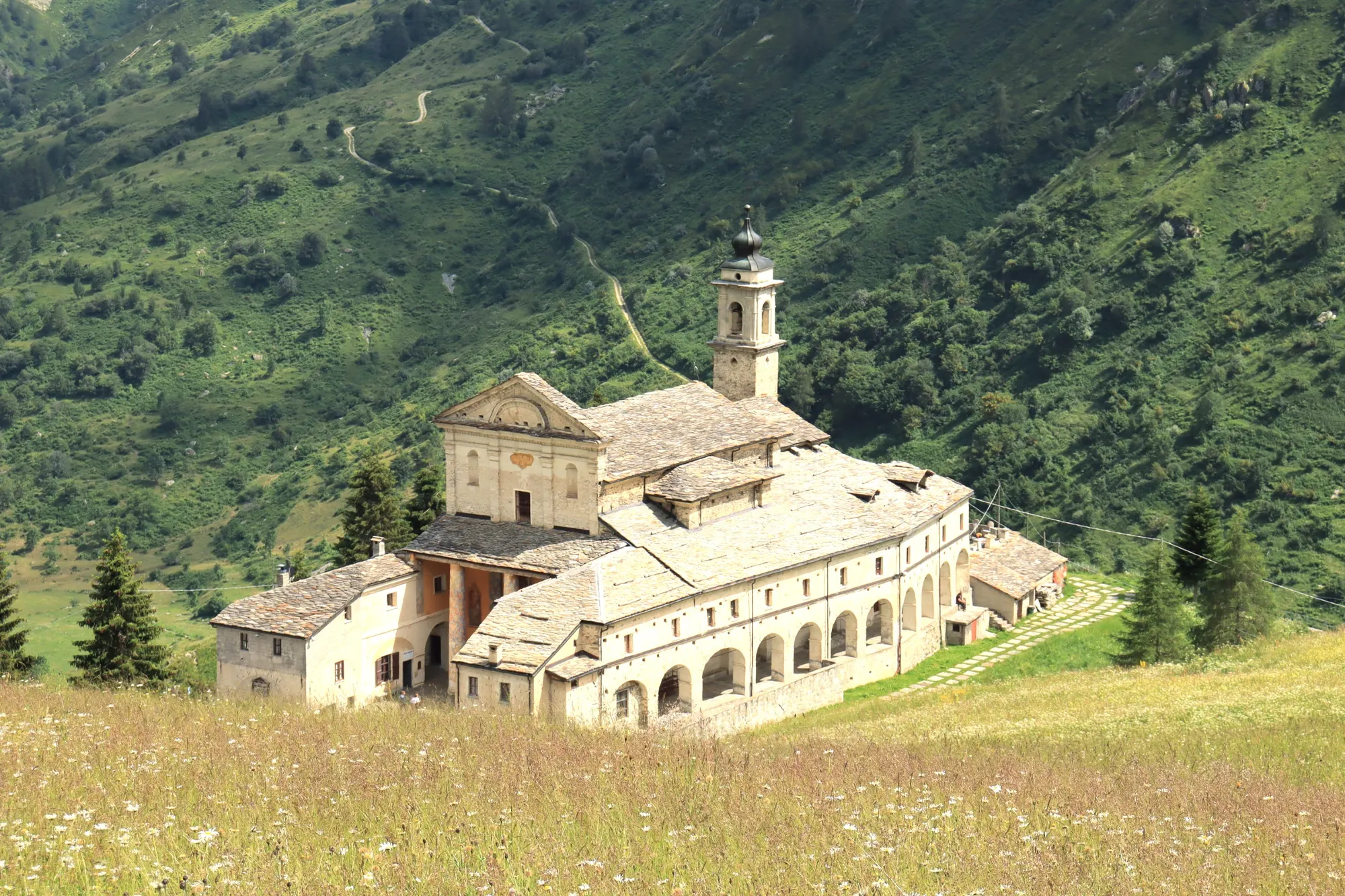 Hillside sanctuary with its arcaded front, set against wooded slopes